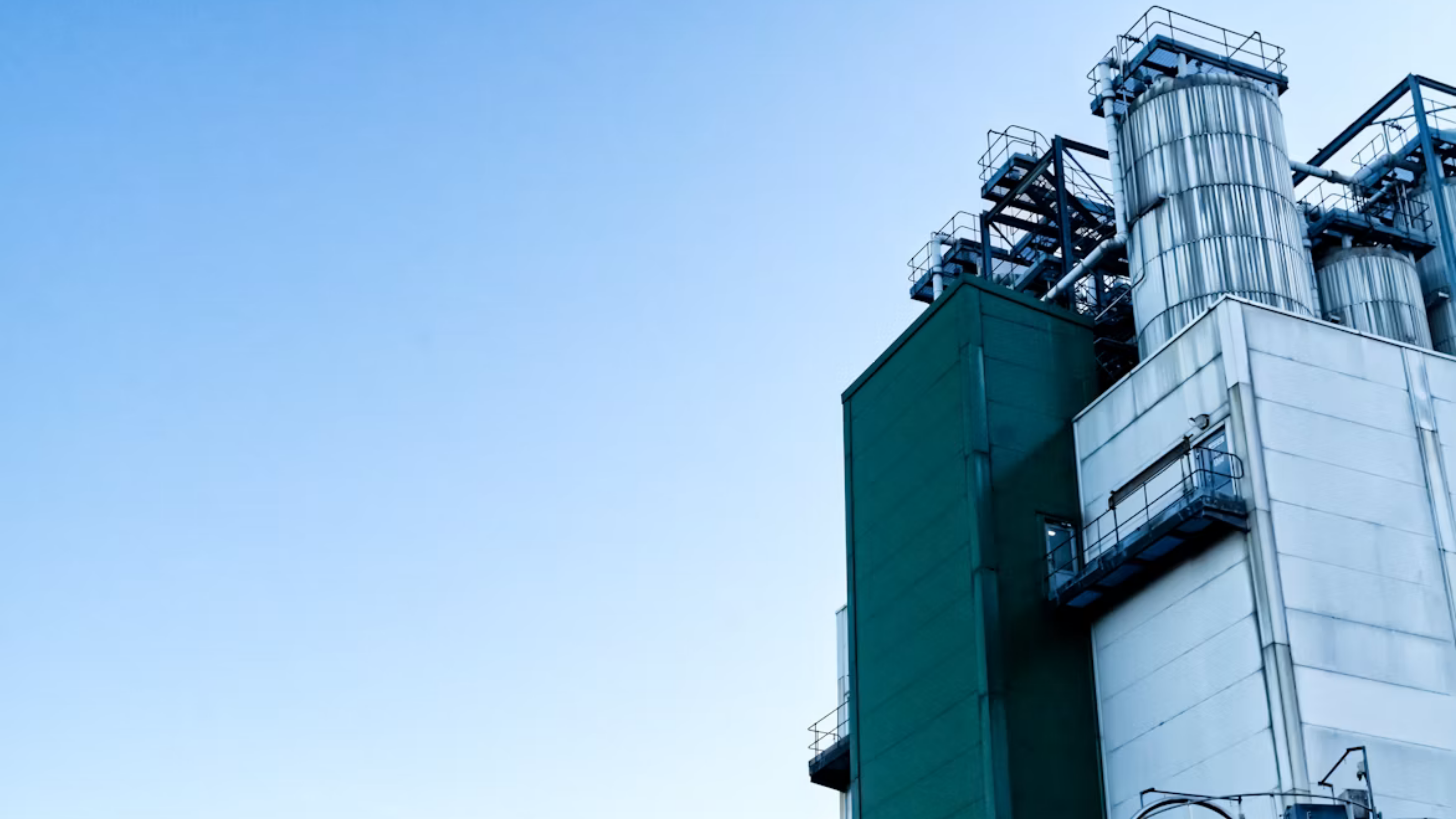 Interior de fábrica têxtil com trabalhadores em máquinas de costura